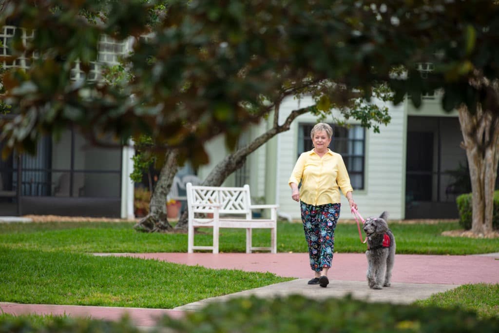 Senior woman walking her dog at a senior living community