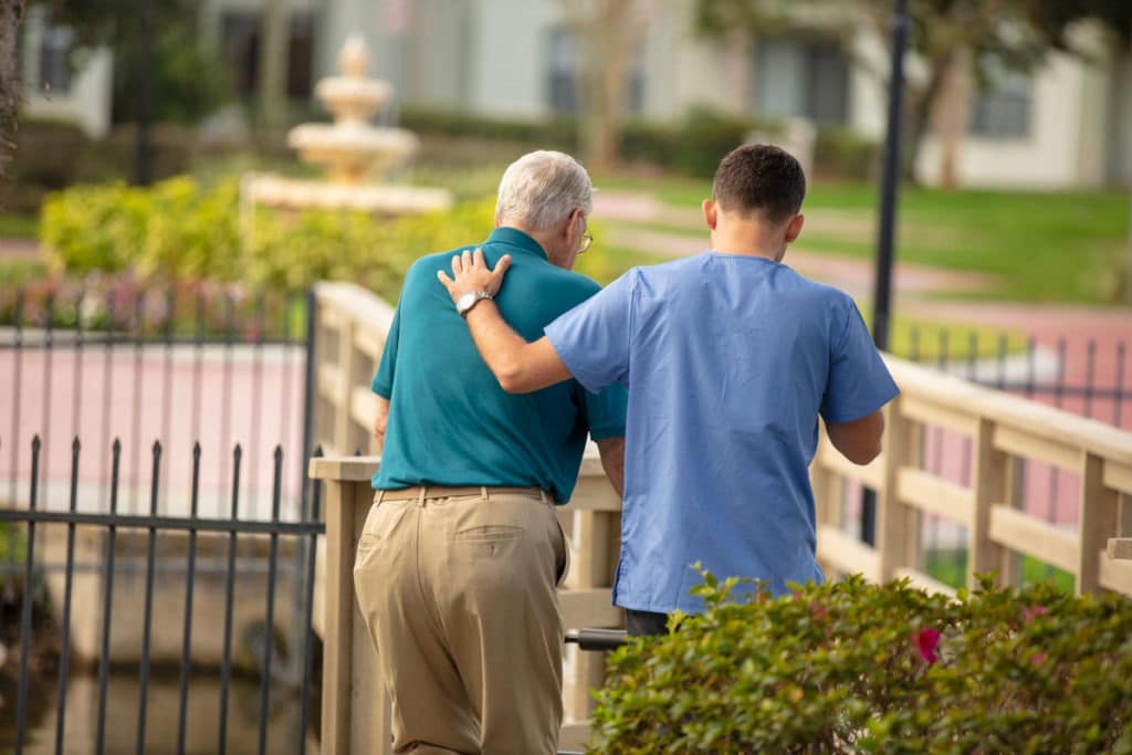 caregiver walking with senior man