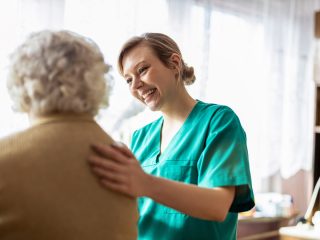 nurse patting older woman on the back