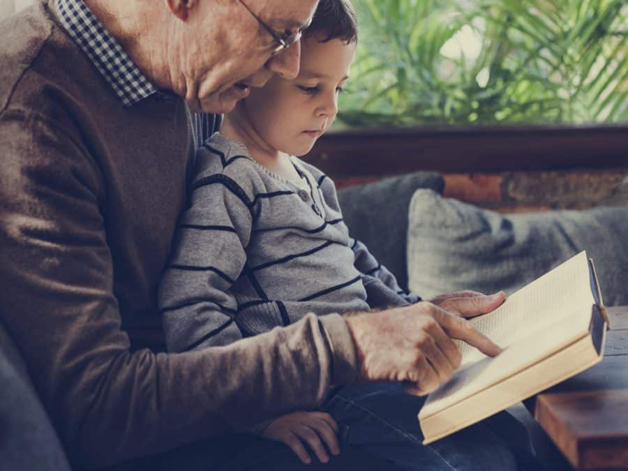 older man reading to a little boy