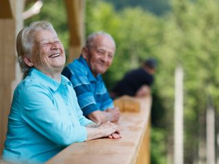 older couple leaning on the rail and laughing