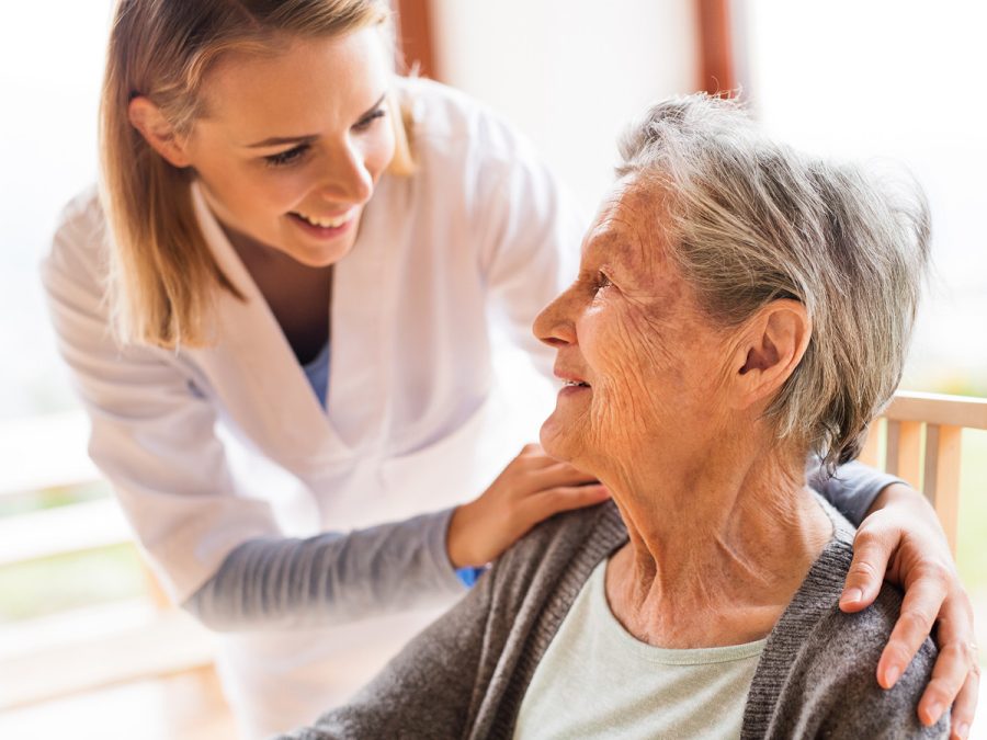 older woman being comforted by her nurse