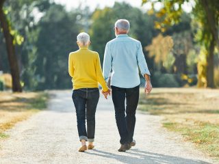 older couple holding hands and taking a walk