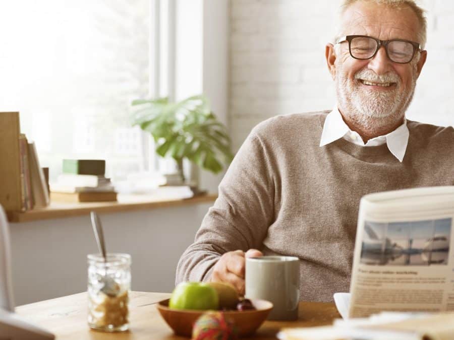 older man reading the paper at breakfast