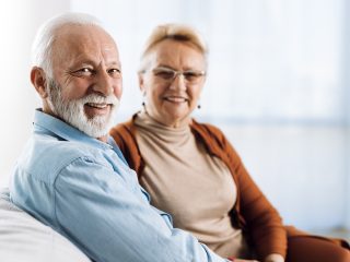 older couple sitting on the couch smiling
