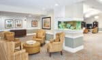 Assisted Living lounge area with chairs coffee table and aquarium