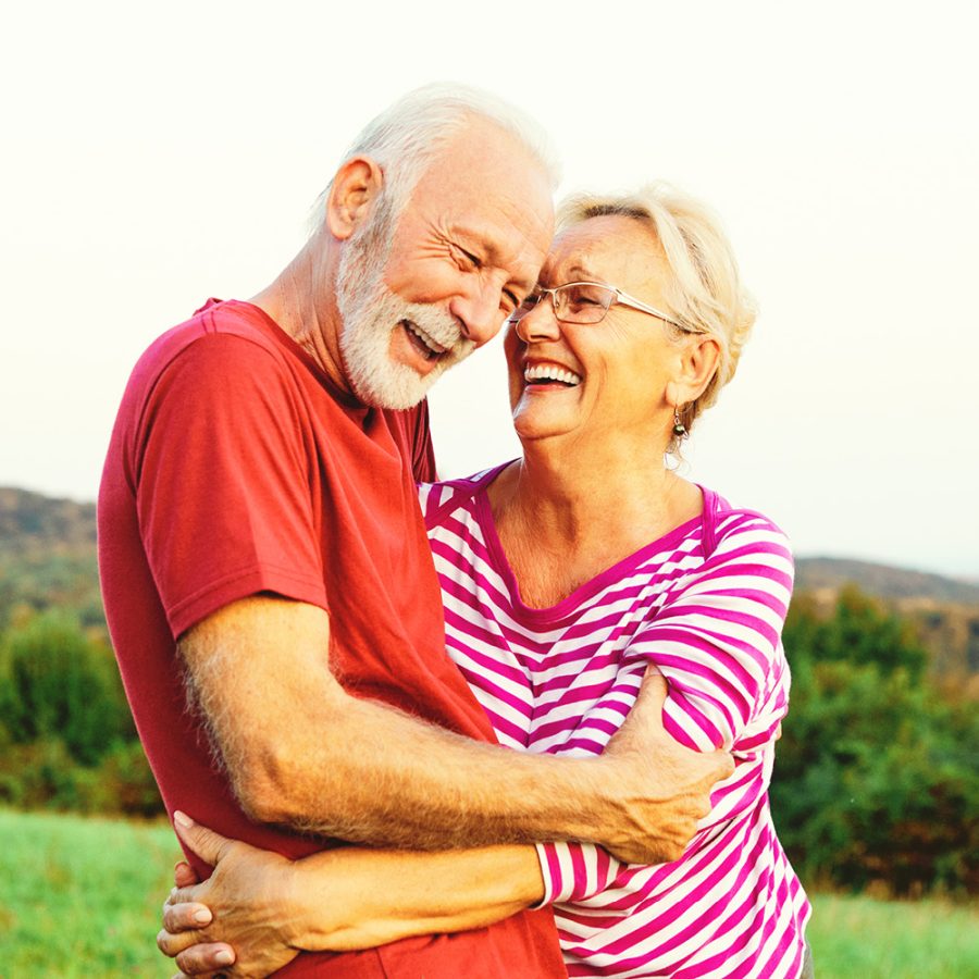 older couple hugging and laughing outside
