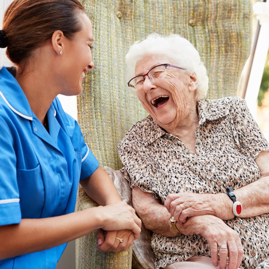 older woman laughing with her nurse