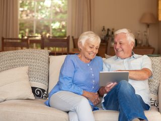 couple laughing and lookin at a tablet