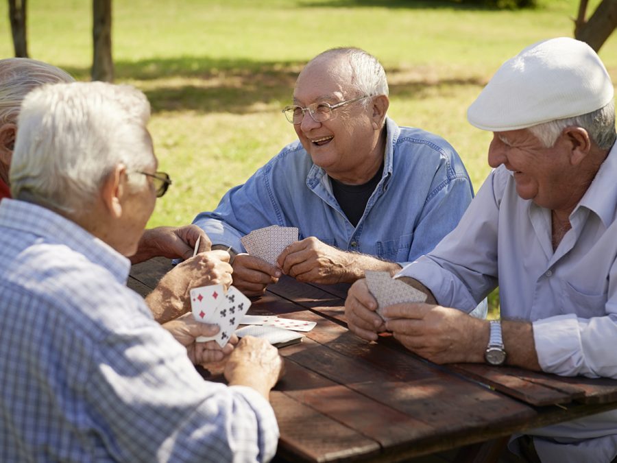 older people playing cards outside