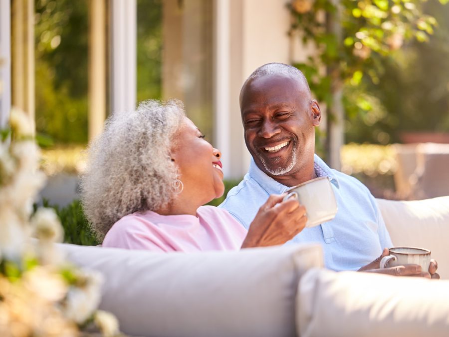 older couple laughing and drinking coffee