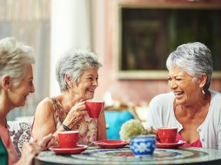 older ladies laughing and drinking coffee