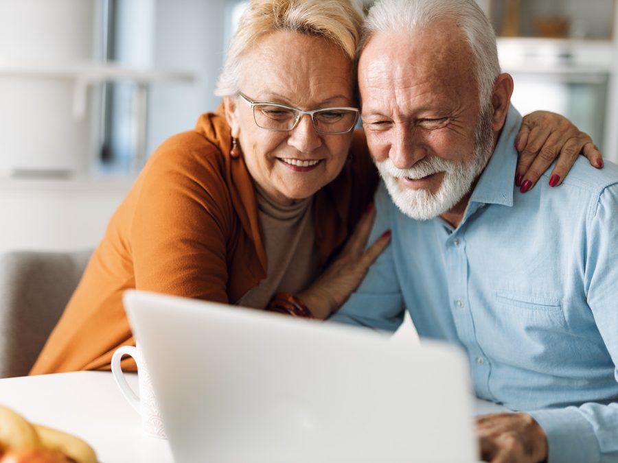 older couple smiling at laptop